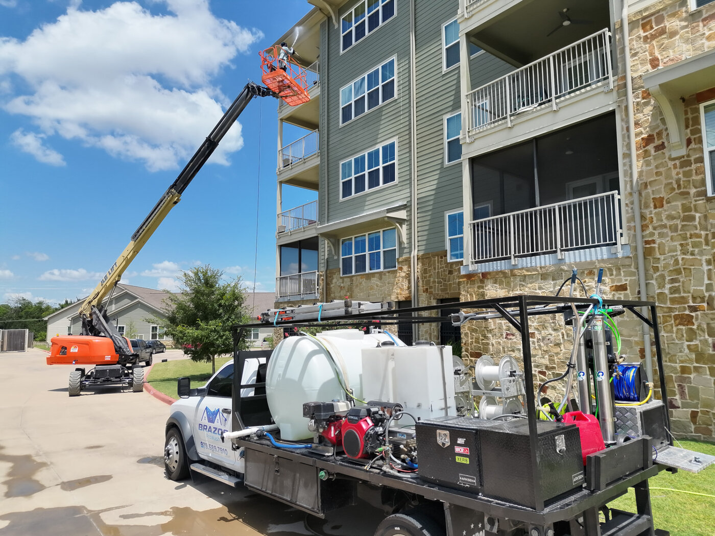 Brazos Pro Wash rig and boom lift at a multi-story apartment complex